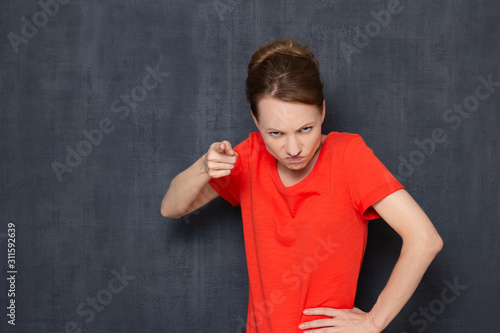 Portrait of angry annoyed girl pointing at you and making reprimand