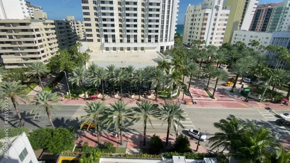 A high angle view of traffic and pedestrians on Collins Avenue in Miami Beach, Florida on a sunny summer day. A high angle view of traffic and pedestrians on Collins Avenue in Miami Beach, Florida on a sunny summer day.