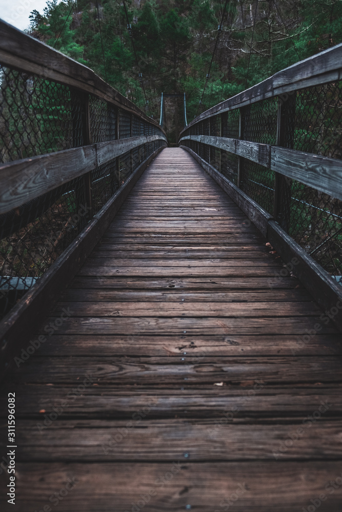Moody empty bridge leading into a dark forest in Tallulah Falls Georgia Moody empty bridge leading into a dark forest in Tallulah Falls Georgia