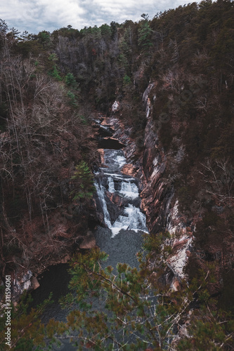 Over looking a water fall pouring into a river in a dark forest in Tallulah Falls, Georgia © KatherineGregorio