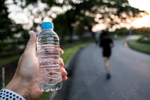 Close up of plastic water bottle hand On drinking water After run.