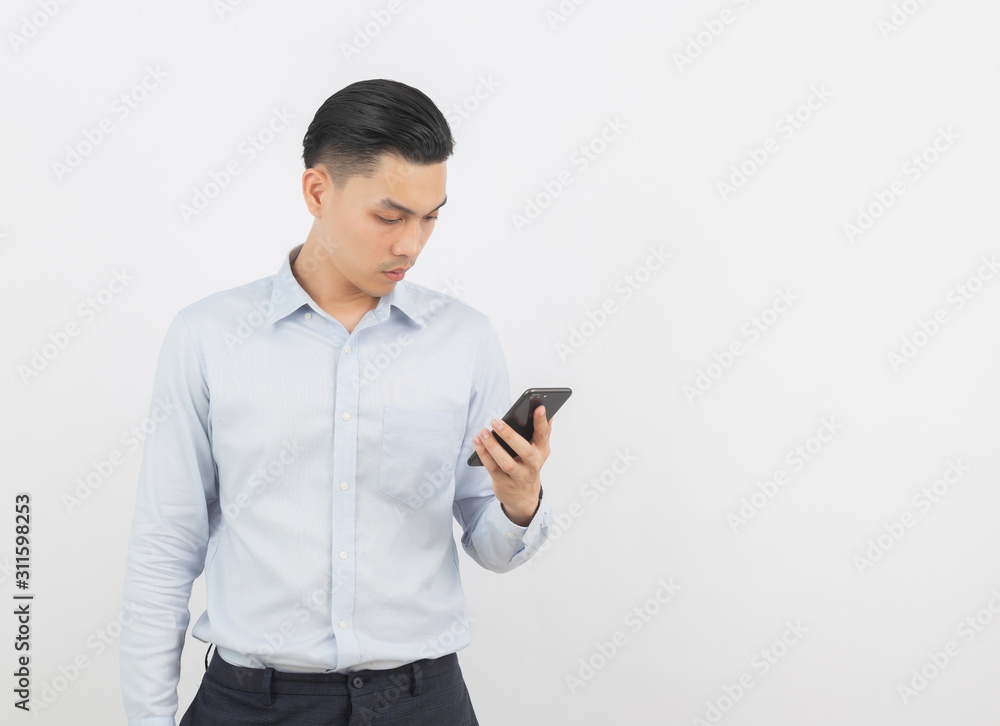 Young handsome asian business man playing smartphone and thinking isolated on white background. Young handsome asian business man playing smartphone and thinking isolated on white background.