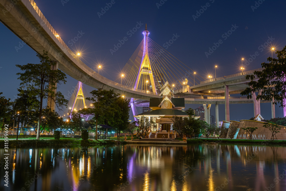 Night photography of Bhumibol Bridge with a reflection from Lat Pho Park in Bangkok