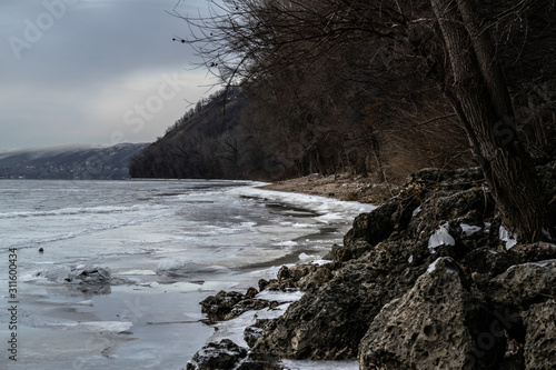Landscape of the Volga river shore and Zhiguli mountains with forest during cold winter day with gray clouds near Samara city