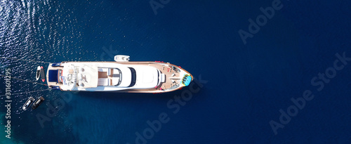 Aerial drone top down ultra wide photo of small yacht docked in tropical exotic turquoise sea © aerial-drone