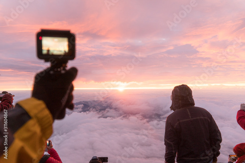 The hand holding camera to record the sun rising moment on Japan Fuji mountain, selective focus