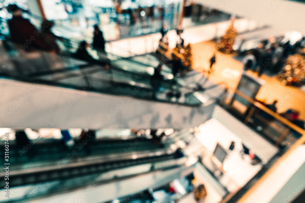 Abstract blurred background of the shopping center. Unfocused escalators with people Abstract blurred background of the shopping center. Unfocused escalators with people