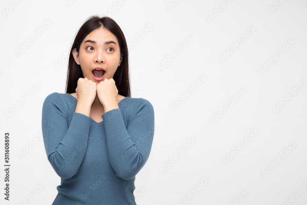 Portrait of excited screaming young asian woman standing in pink dress isolated over white background, Wow and surprised concept