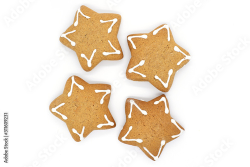 four star-shaped gingerbread cookies on a white background