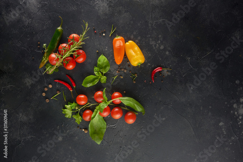 Spices, herbs, vegetables on black slate background. Top view with copy space