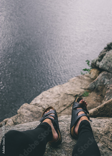 Sandals on Feet Dangling off Cliff