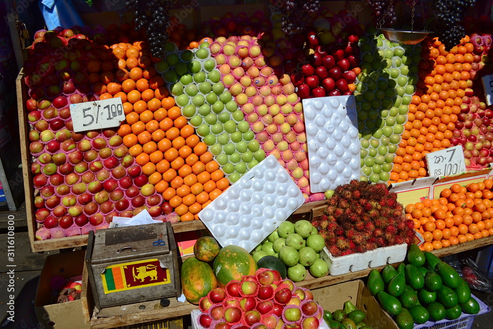 Obraz premium Street market stall with colorful fruits. Wooden box with small Sri Lankan flag. Small business for selling healthy food. Kandy, Sri Lanka