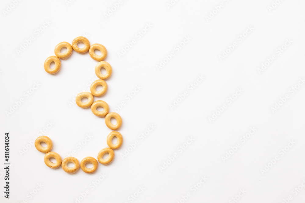 Obraz premium number 3 made from cookies on a white background with space for text. layout for school or diet