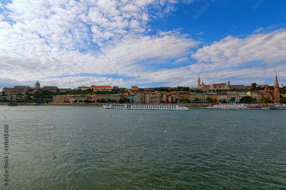 Panoramic view of picturesque Danube River and Buda side with Fisher Bastion and Buda Castle (Royal Palace) against colorful vibrant sky. Autumn in Budapest, Hungary
