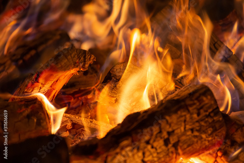 Hot fireplace full of wood and fire burning, closeup