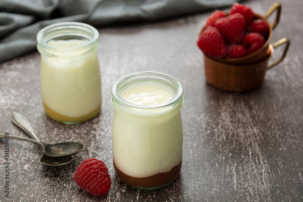 Fresh yogurt in glass jar with fruits on dark background. Healthy food, milk diary. Fresh yogurt in glass jar with fruits on dark background. Healthy food, milk diary.