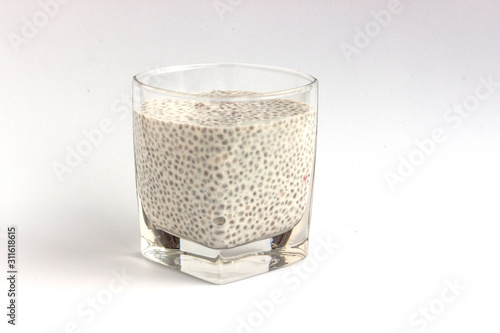 Healthy dessert pudding with chia seeds in a glass cup on a white background.  Diet food and weight loss concept.  Minimal design