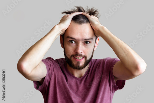 panic of a businessman with hands in his head in a shirt on a light background