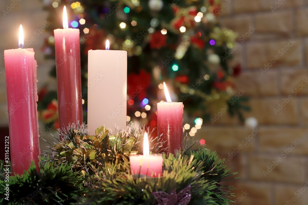 corona de adviento, cinco velas encendidas, arbol de navidad en el fondo  con luces desenfocadas Stock Photo | Adobe Stock