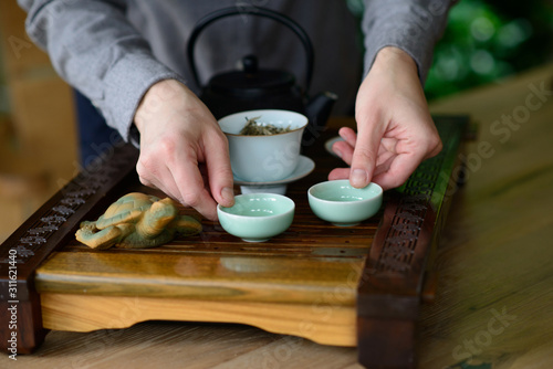 Professional hands of a tea master are cooking show a tea ceremony. Tea ceremony set. White Chinese tea.