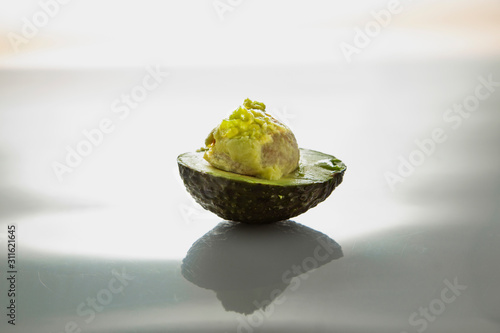 half of the avocado on a bright background