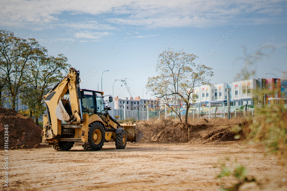 the excavator bulldozer machine working to build the new apartment complex