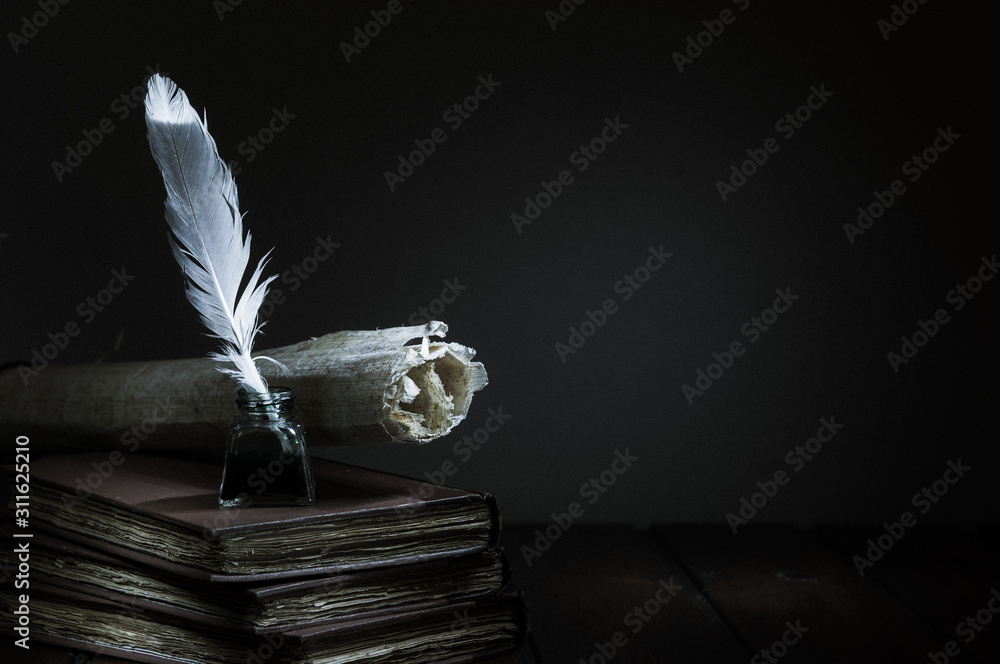 Quill pen and rolled papyrus sheets on a wooden table with old books, high contrast
