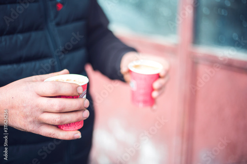 Man holding two cups of coffee