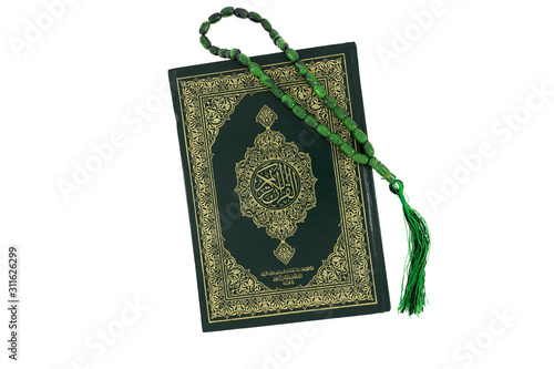 Quran and green rosary beads isolated on white background. Arabic word translation : The Holy Al Quran (holy book of Muslims). Islamic concept with copy space.