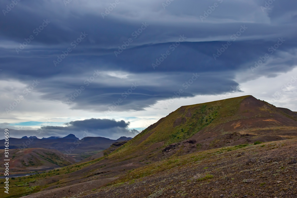 Beautiful clouds over the hilly landscapes of Iceland. Nature and places for wonderful travels