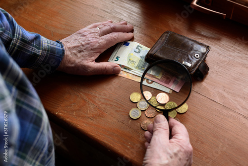 The hands of an old man and counting money, euros. The concept of poverty, low income, austerity in old age. photo