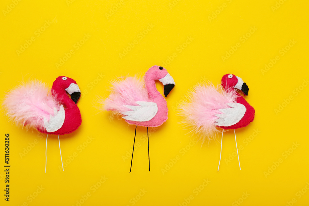 Soft toy of flamingos on yellow background Soft toy of flamingos on yellow background