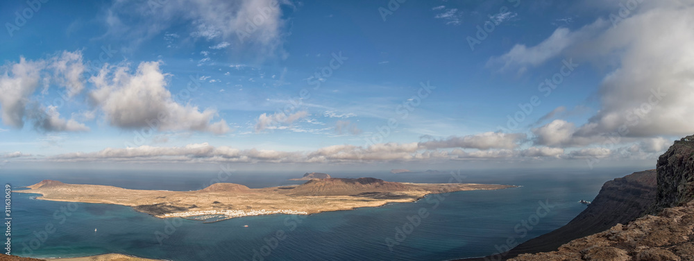 Obraz premium Aerial view of La Graciosa Island from Lanzarote against a dramatic sky, Canary Islands, Spain