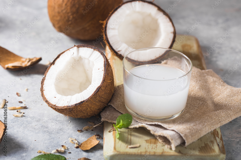 Cracked fresh coconut, milk and slice nut on concrete background, space for text Food ingredients, healthy lifestyle, paradise concept Cracked fresh coconut, milk and slice nut on concrete background, space for text Food ingredients, healthy lifestyle, paradise concept