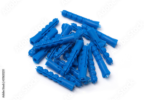 Pile of brass screws and blue plastic dowels lying on flat surface