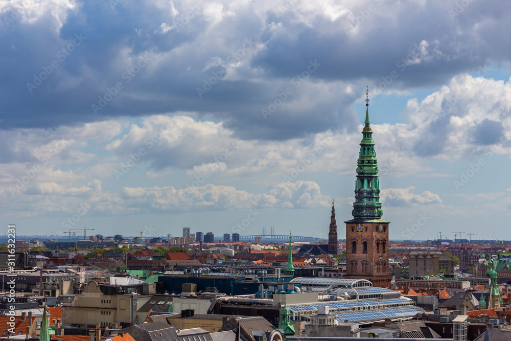 Copenhagen skyline. Denmark capital city streets and danish house roofs. Copenhagen old town and copper spiel of Nikolaj Church panoramic view from top.