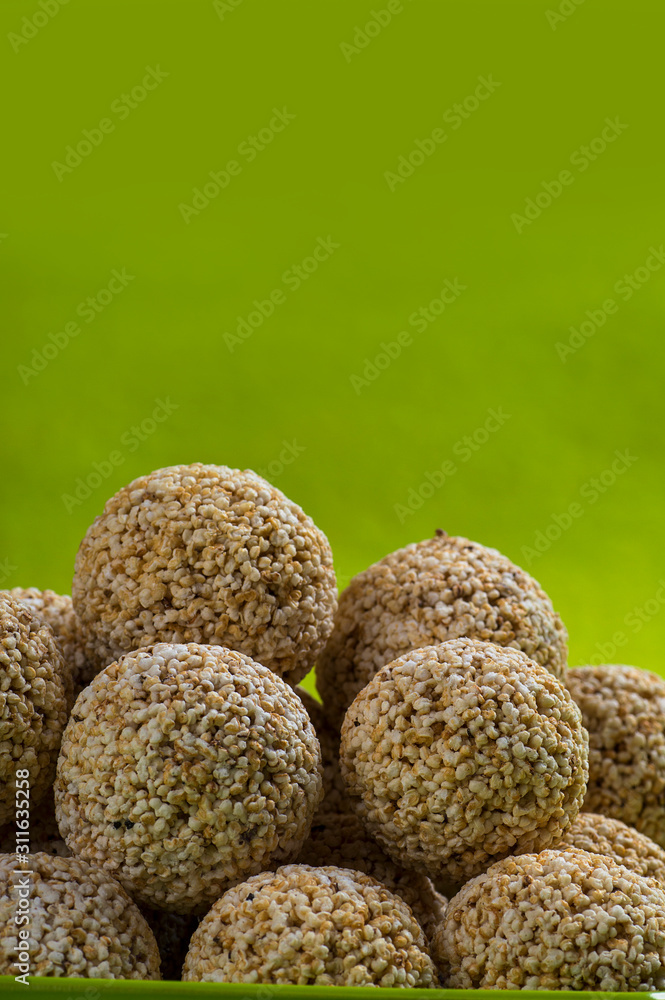 Amaranth or Rajgira laddu, Cholai ke laddo in green plate on green background Amaranth or Rajgira laddu, Cholai ke laddo in green plate on green background
