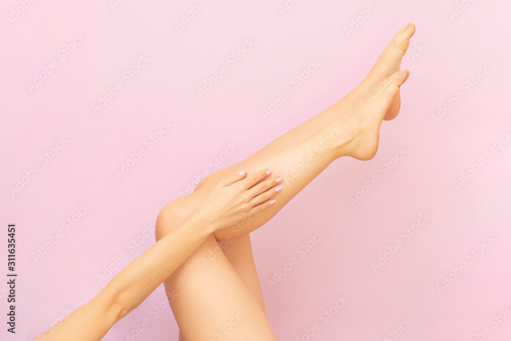 Beautiful long female legs with smooth skin after depilation on a pastel pink background. The concept of clean skin, waxing, shugaring, laser hair removal Beautiful long female legs with smooth skin after depilation on a pastel pink background. The concept of clean skin, waxing, shugaring, laser hair removal