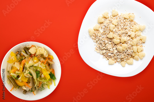 Healthy breakfast on a white plate on a colored background. Muesli with vegetable salad top view photo