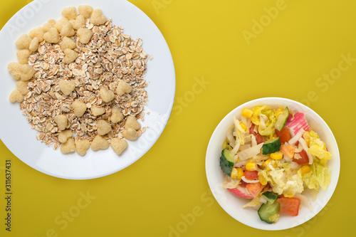 Healthy breakfast on a white plate on a colored background. Muesli with vegetable salad top view photo