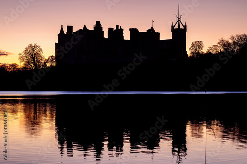 Silhouette of an old castle on the lake against the backdrop of the rising sun. Linlithgow Palace, Scotland