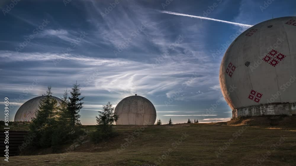 Unusual architecture concept. Dramatic sunrise over uniquely designed old radar station in shape of white spheres with red pattern. Time lapse video with cool clouds and perfect sunset. Time lapse wit Unusual architecture concept. Dramatic sunrise over uniquely designed old radar station in shape of white spheres with red pattern. Time lapse video with cool clouds and perfect sunset. Time lapse wit