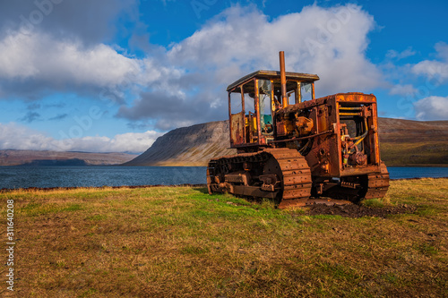 old broken bulldozer(tractor) in Icelandic Arnarfjordur. Iceland, september 2019. Beautiful sunny day.