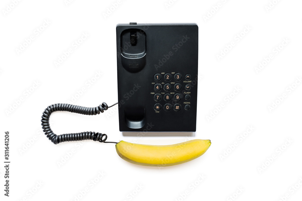 Creative photo of a simple modern black push-button telephone with a bright yellow banana instead of a handset, isolated on a white background. Creative photo of a simple modern black push-button telephone with a bright yellow banana instead of a handset, isolated on a white background.