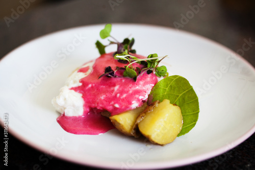 Decorative dinner plate of eggs, potatoes and a pink sauce