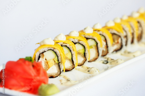 Sushi roll wrapped with egg with a white background