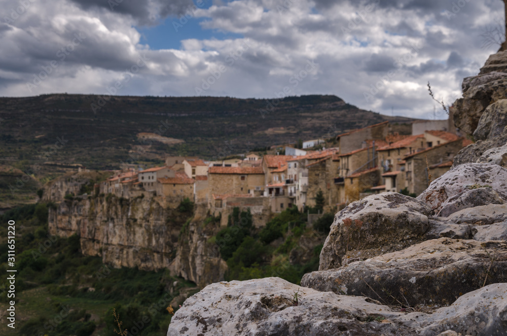 Landscape of the town of Cantavieja with its houses on the edge of the precipice and the Church of the Assumption and its dome on the right on a cloudy day, Cantavieja, Teruel, Spain