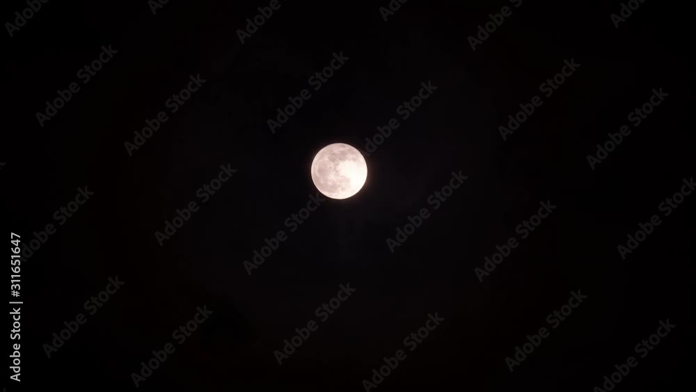 Close-up of bright full moon with moving clouds background at night, 4k footage, time lapse, clouds lighted by moon light. Close-up of bright full moon with moving clouds background at night, 4k footage, time lapse, clouds lighted by moon light.