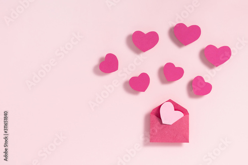 Valentine's day frame composition. Purple pink hearts blank sheet of paper on pastel pink background. Top view, flat lay, copy space