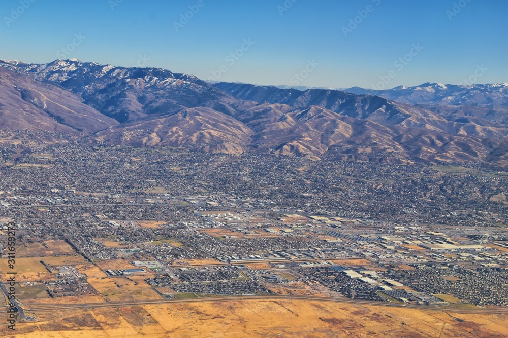 Fototapeta premium Wasatch Front Rocky Mountain Range Aerial view from airplane in fall including urban cities and the Great Salt Lake around Salt Lake City, Utah, United States of America. USA.